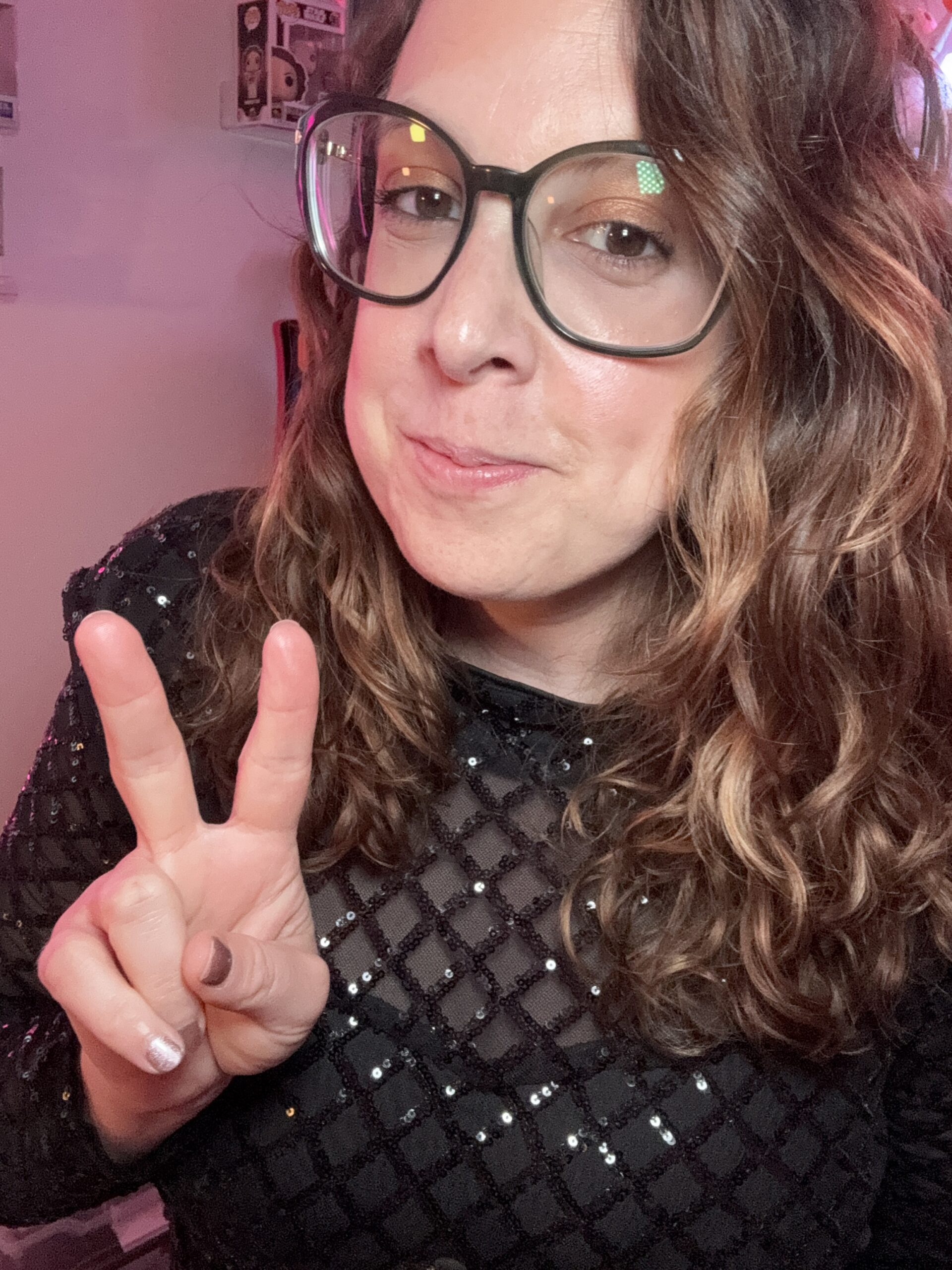 Up-close of Grapple in a black shiny top with the peace sign.